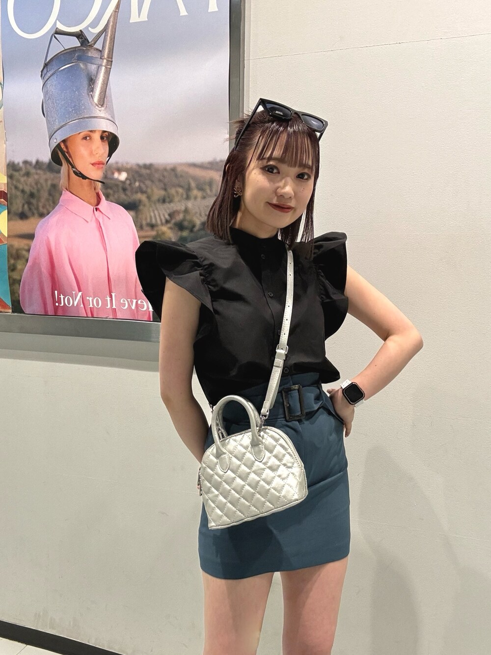 ブラック系のシャツ/ブラウス、ブルー系のスカート、ブラック系のブーツを着用したレディースの春コーディネートの6枚目の写真