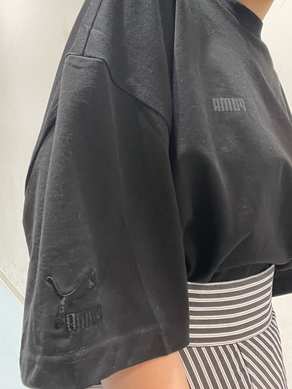 ブラック系のショルダーバッグ、ブラック系のTシャツ/カットソー、ブラック系のサンダルを着用したレディースの春コーディネートの6枚目の写真