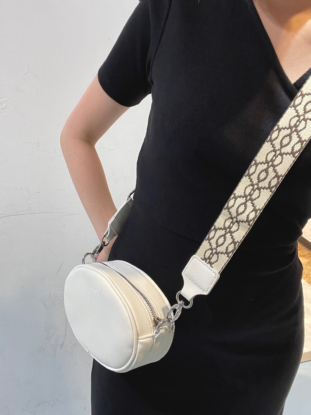 ブラック系のワンピース、ホワイト系のショルダーバッグを着用したレディースの夏コーディネートの6枚目の写真