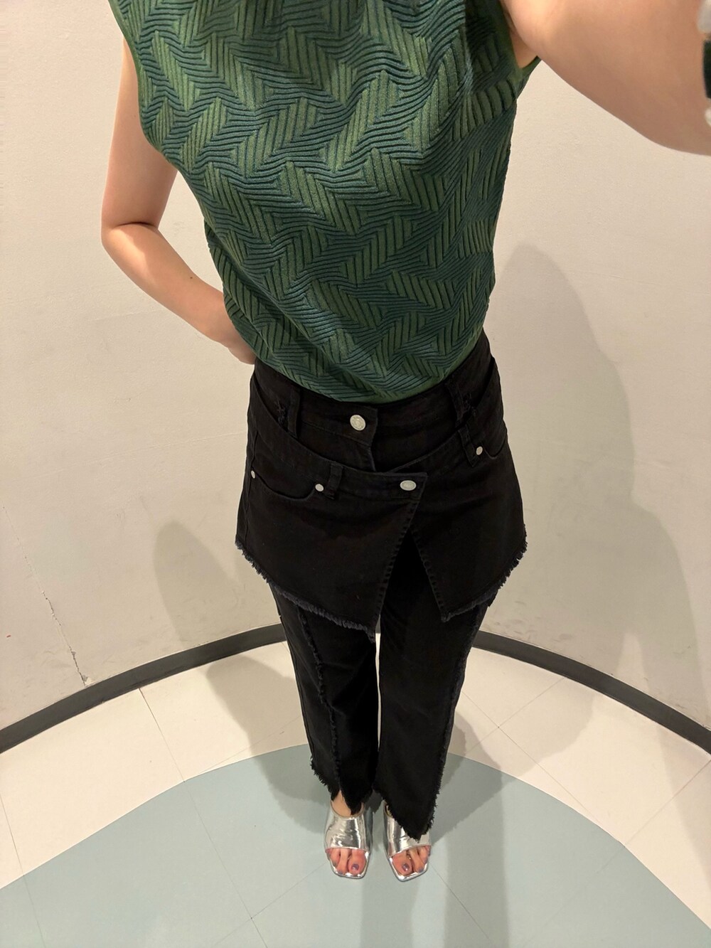 グリーン系のニット/セーター、ブラック系のデニムパンツ、シルバー系のサンダルを着用したレディースの夏コーディネートの4枚目の写真