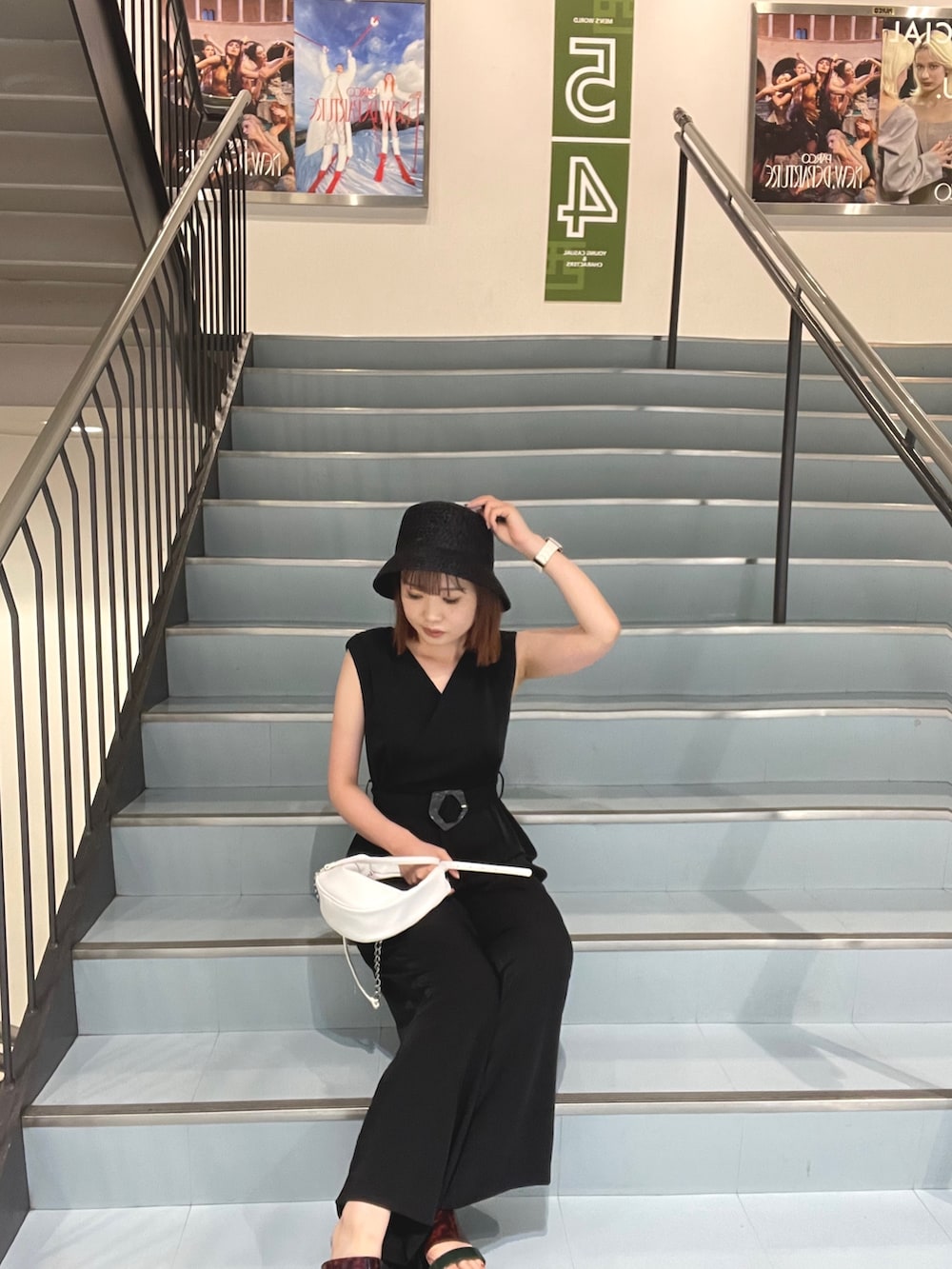 ホワイト系のハンドバッグ、ブラック系のサロペット/オーバーオールを着用したレディースの夏コーディネートの3枚目の写真