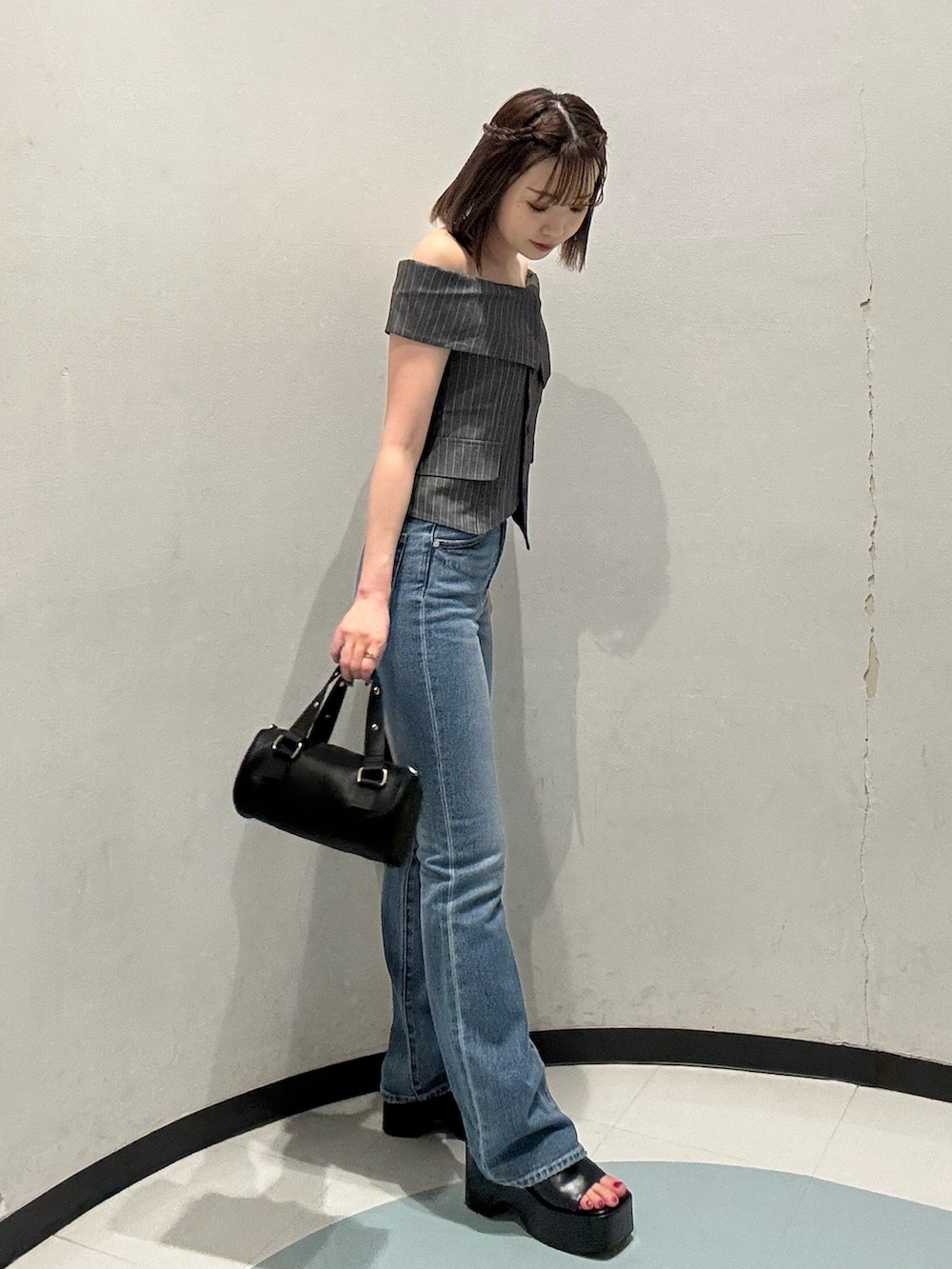 ブラック系のハンドバッグ、グレー系のシャツ/ブラウス、ブラック系のサンダルを着用したレディースの春コーディネートの2枚目の写真