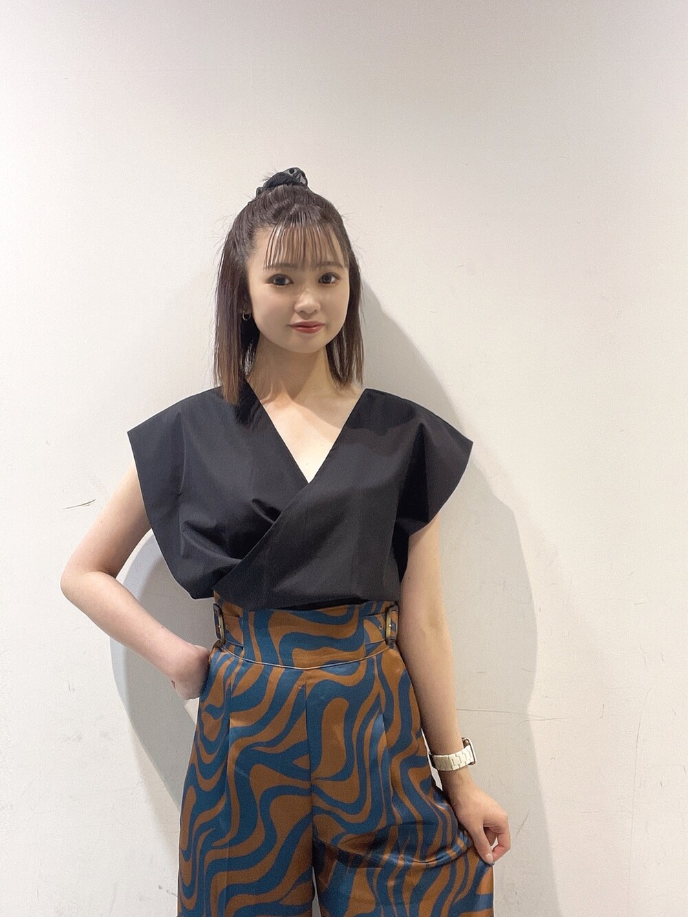 ブラック系のシャツ/ブラウス、ブルー系のスラックス、ホワイト系のハンドバッグを着用したレディースの夏コーディネートの3枚目の写真