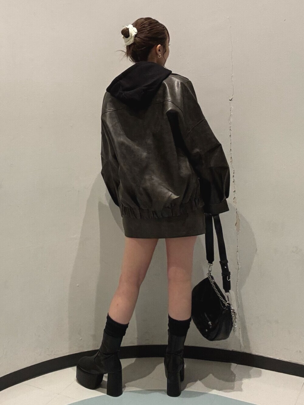 ブラック系のブーツ、ブラック系のパーカー、ブラウン系のブルゾンを着用したレディースの冬コーディネートの3枚目の写真