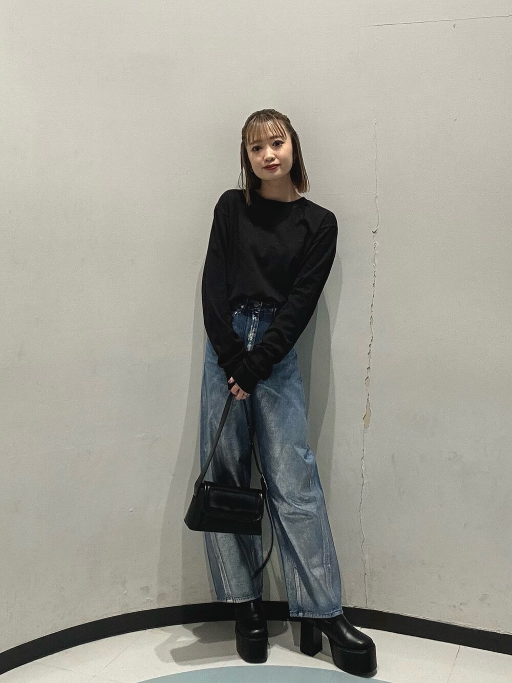 ブルー系のデニムパンツ、ブラック系のショルダーバッグ、グレー系のブルゾンを着用したレディースの冬コーディネートの5枚目の写真