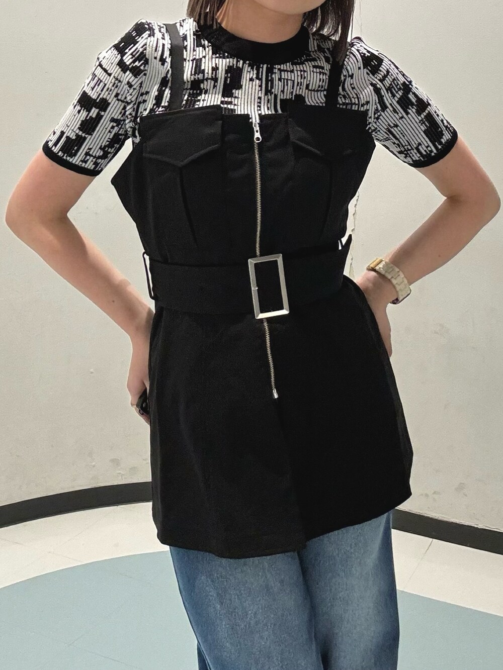 ブラック系のショルダーバッグ、ブラック系のシャツ/ブラウス、ブルー系のデニムパンツを着用したレディースの春コーディネートの4枚目の写真