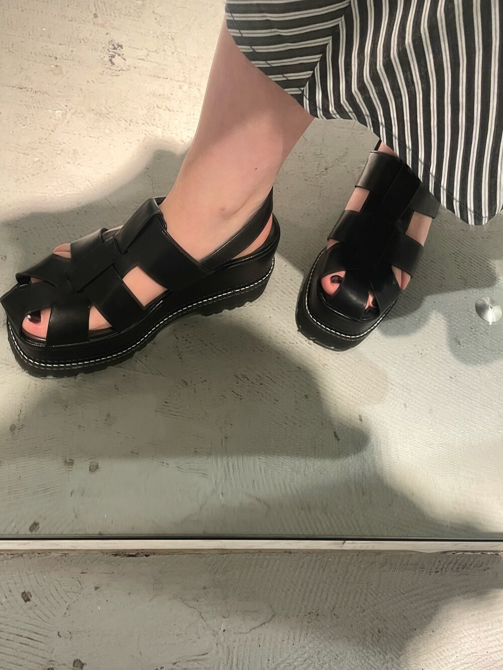 ブラック系のショルダーバッグ、ブラック系のTシャツ/カットソー、ブラック系のサンダルを着用したレディースの春コーディネートの7枚目の写真