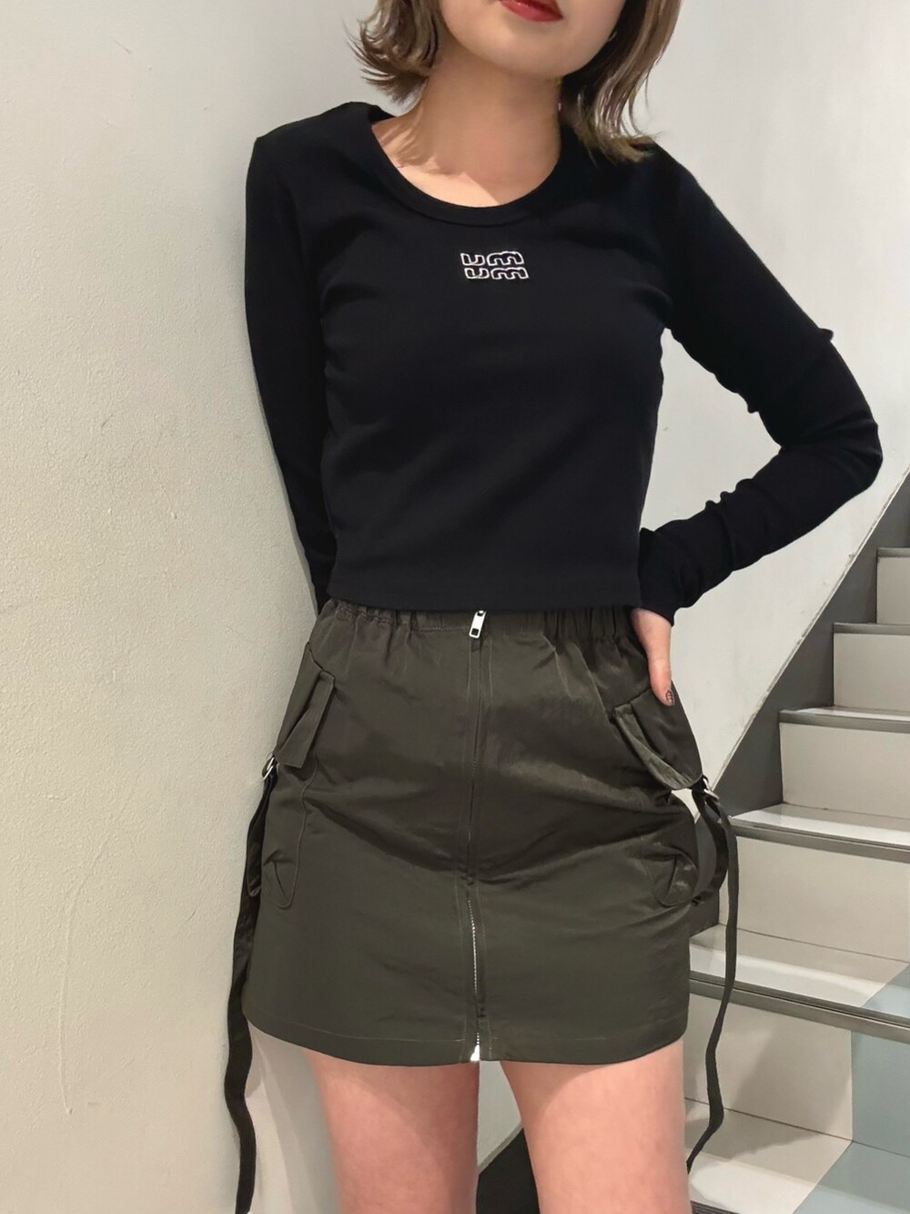 ブラック系のブーツ、ブラック系のTシャツ/カットソー、ベージュ系のスカートを着用したレディースの冬コーディネートの5枚目の写真