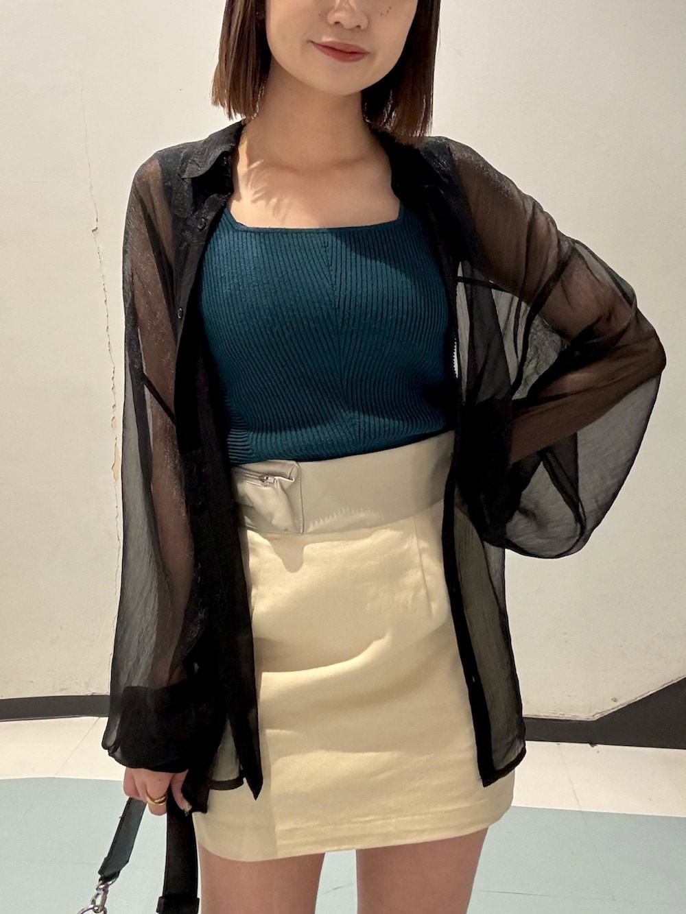 ブラック系のシャツ/ブラウス、グリーン系のニット/セーター、ブラック系のサンダルを着用したレディースの春コーディネートの4枚目の写真