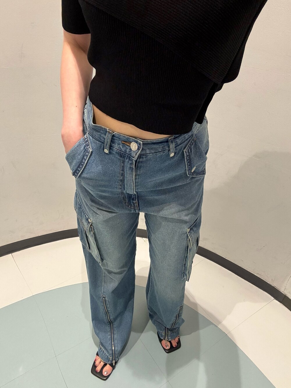 ブラック系のニット/セーター、ブラック系のハンドバッグ、ブラック系のサンダルを着用したレディースの夏コーディネートの5枚目の写真