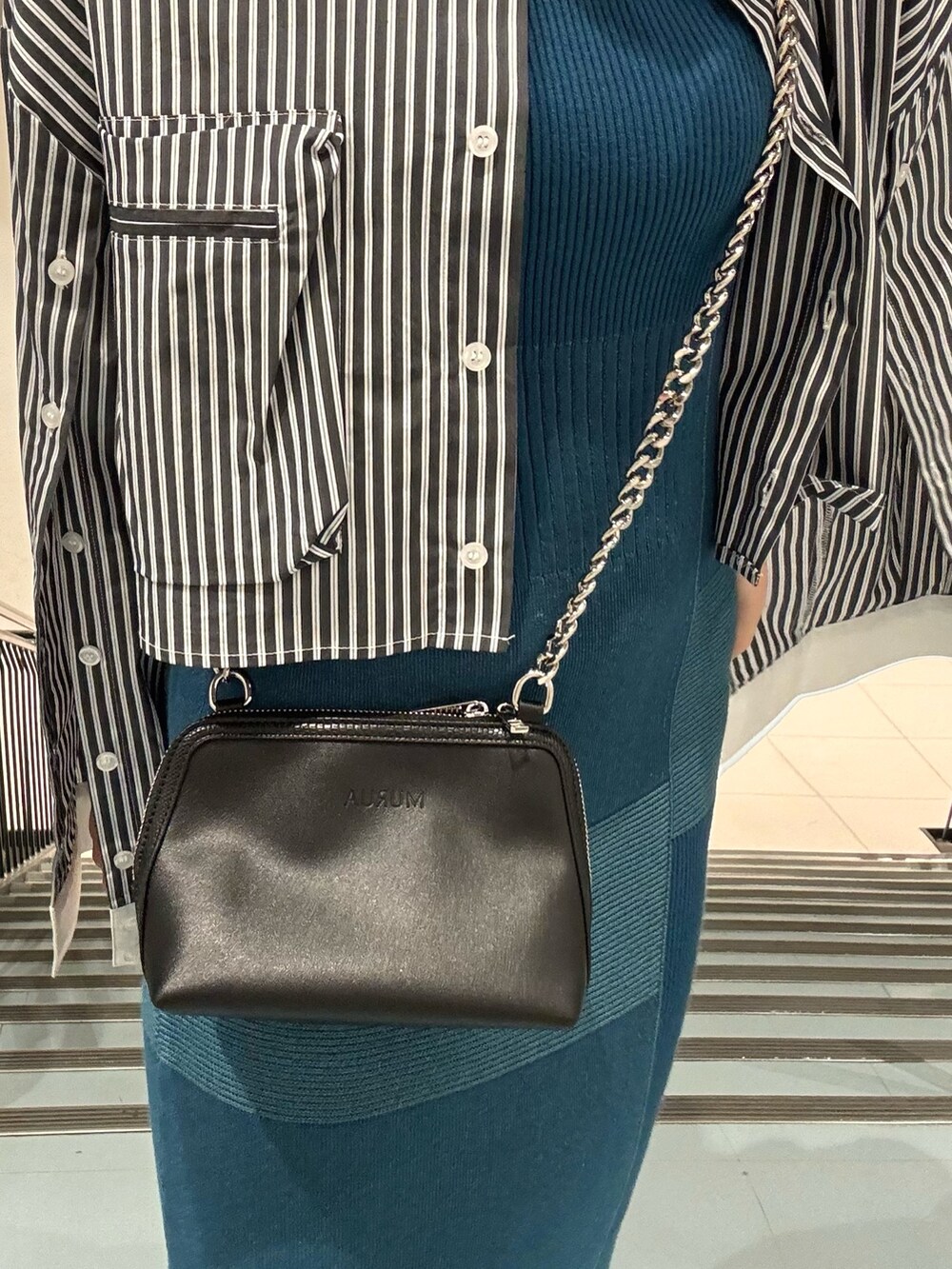 ホワイト系のシャツ/ブラウス、ホワイト系のハンドバッグ、ブルー系のワンピースを着用したレディースの春コーディネートの7枚目の写真