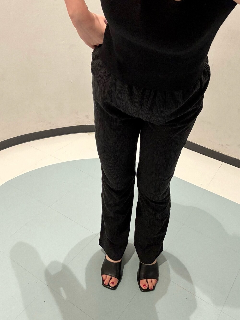 オレンジ系のショルダーバッグ、ブラック系のニット/セーター、オレンジ系のワンピースを着用したレディースの夏コーディネートの6枚目の写真