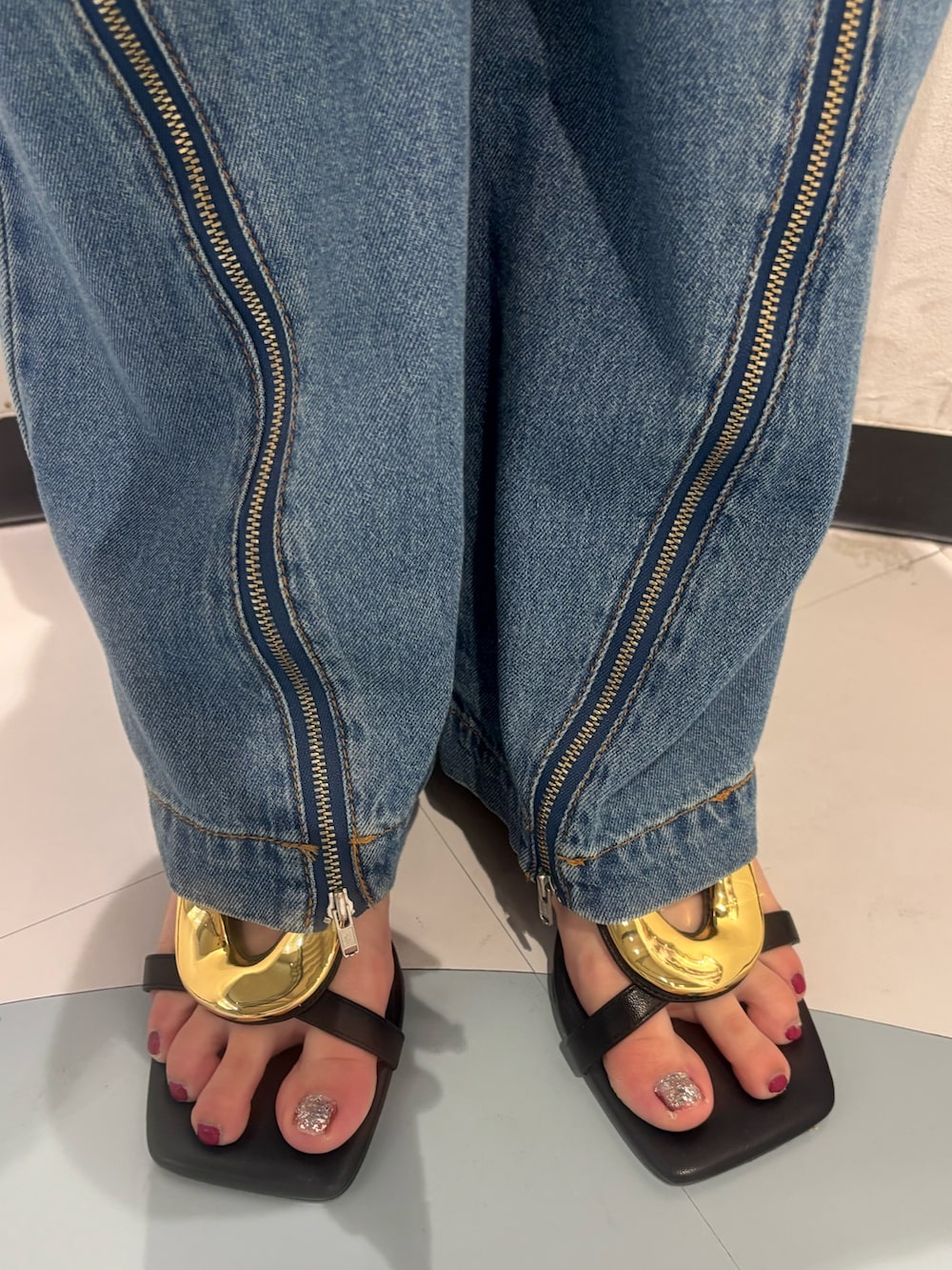 ブラック系のニット/セーター、ブラック系のハンドバッグ、ブラック系のサンダルを着用したレディースの夏コーディネートの7枚目の写真