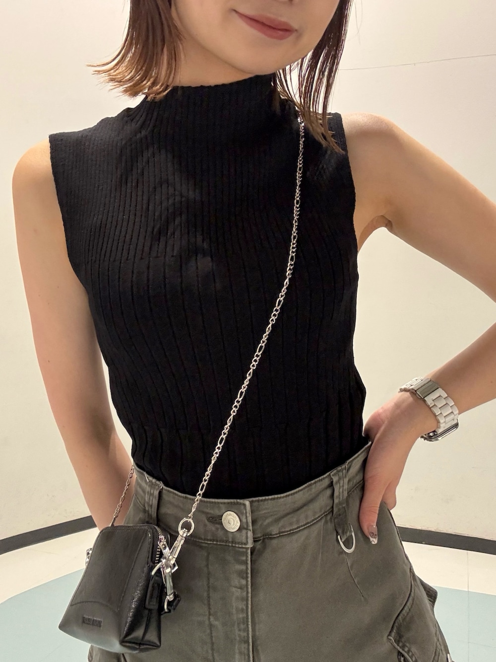 ブラック系のニット/セーター、ブラック系のサンダル、グレー系のスカートを着用したレディースの夏コーディネートの4枚目の写真