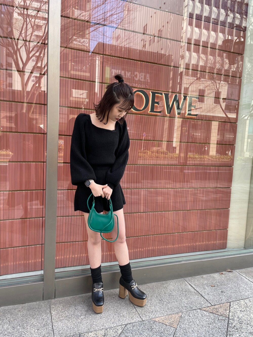 グレー系のチェスターコート、ブラック系のワンピース、ブラック系のローファーを着用したレディースの冬コーディネートの2枚目の写真