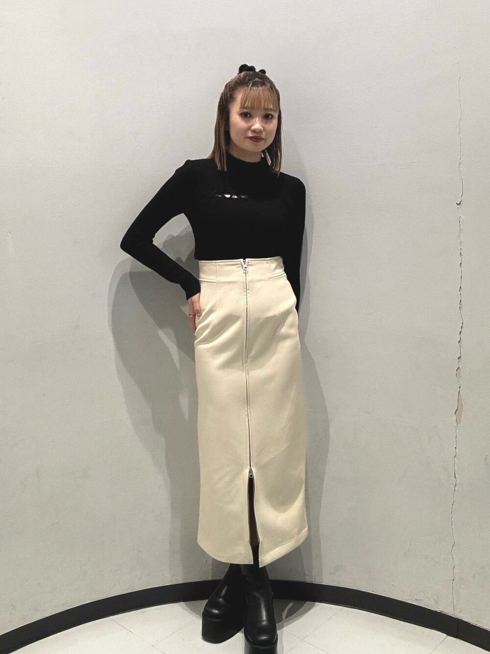 グレー系のダウンジャケット/コート、ホワイト系のニット/セーター、ブラック系のスカートを着用したレディースの秋コーディネートの2枚目の写真