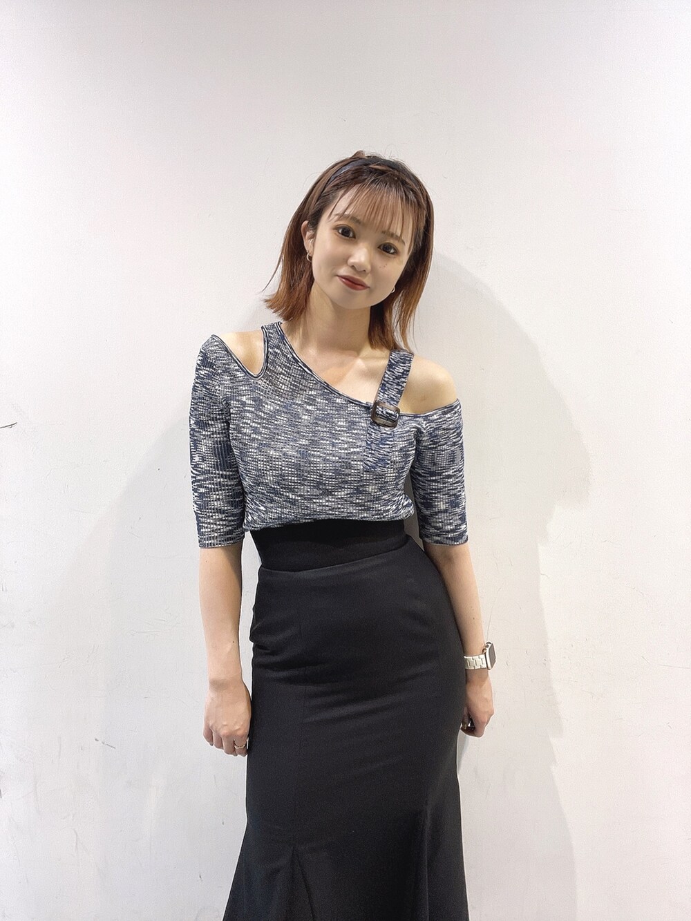 ブラック系のスカート、ブルー系のニット/セーター、ブラック系のサンダルを着用したレディースの春コーディネートの2枚目の写真