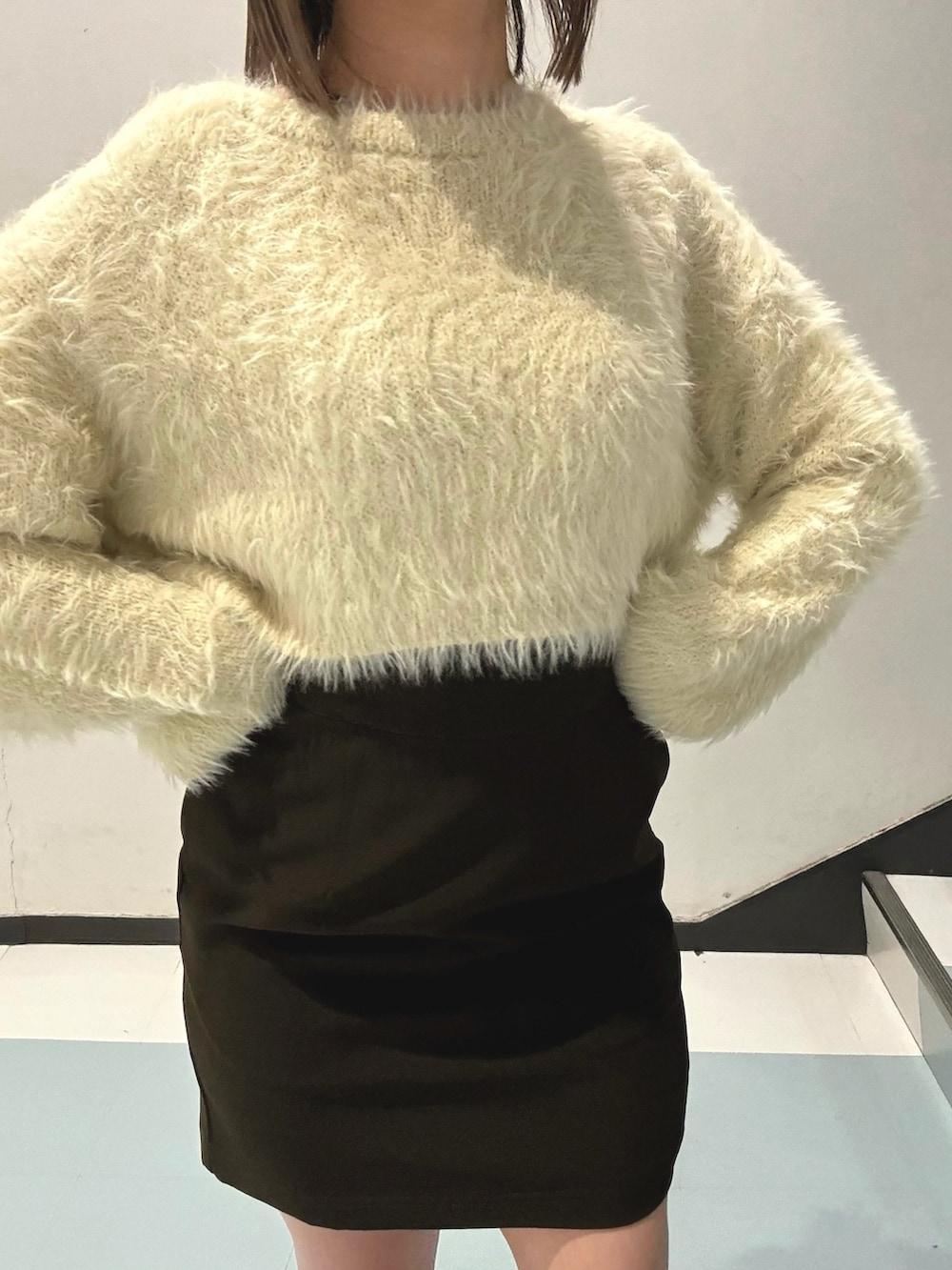 ブルー系のピーコート、ホワイト系のニット/セーター、ブラック系のスカートを着用したレディースの秋コーディネートの7枚目の写真