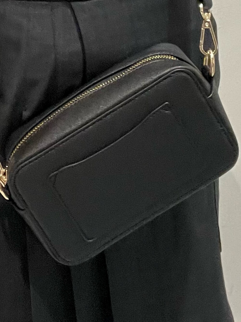 ブラック系のトレンチコート、グレー系のスカート、ブラック系のショルダーバッグを着用したレディースの夏コーディネートの6枚目の写真