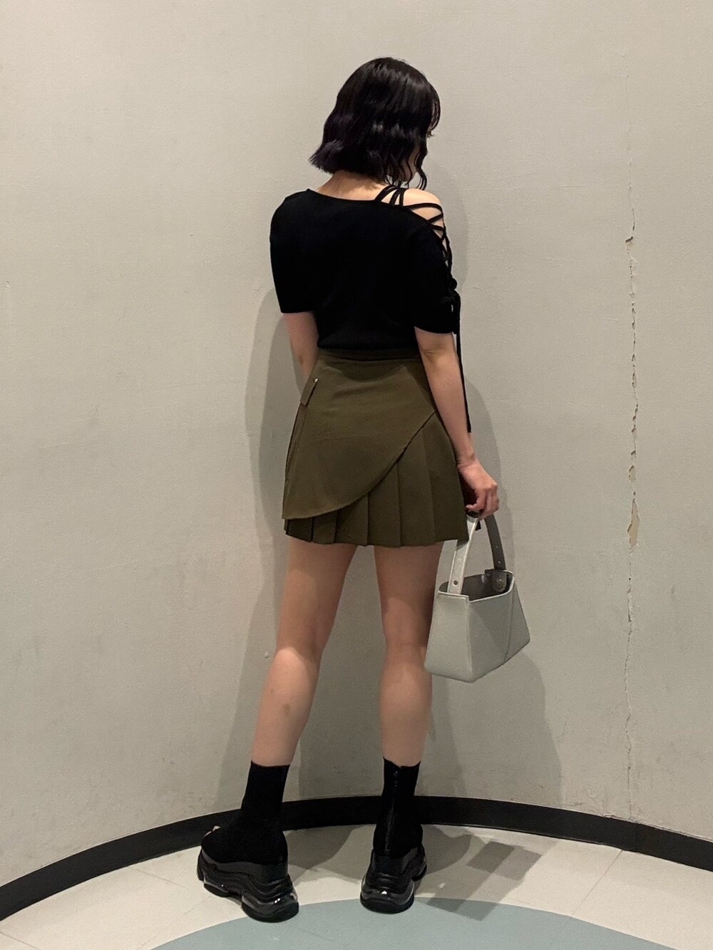 シルバー系のハンドバッグ、ブラック系のサンダル、ブラック系のニット/セーターを着用したレディースの夏コーディネートの3枚目の写真