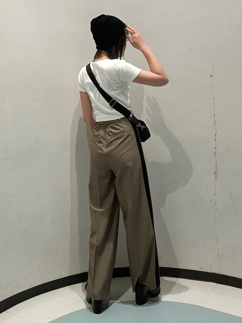 ブラック系のショルダーバッグ、ブラック系のサンダル、ホワイト系のTシャツ/カットソーを着用したレディースの春コーディネートの3枚目の写真