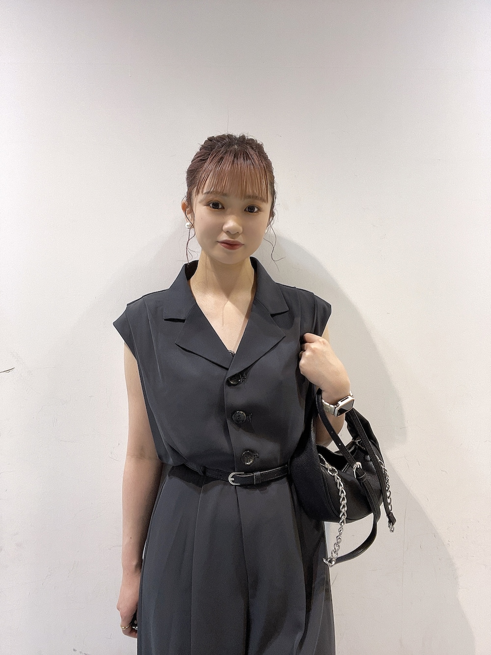 ブラック系のハンドバッグ、ホワイト系のつなぎ/オールインワン、ホワイト系のサンダルを着用したレディースの春コーディネートの3枚目の写真