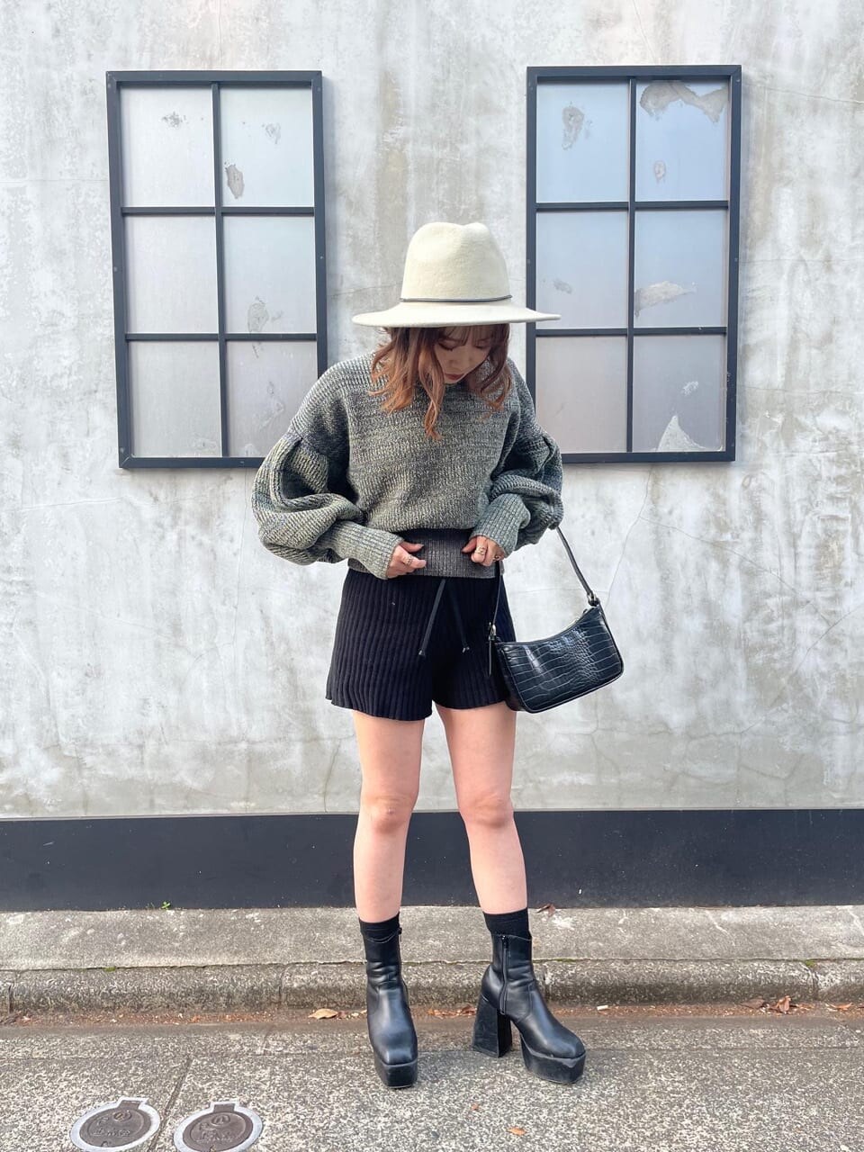 ホワイト系のカーディガン/ボレロ、ホワイト系のハンドバッグ、ブラック系のその他パンツを着用したレディースの冬コーディネートの2枚目の写真