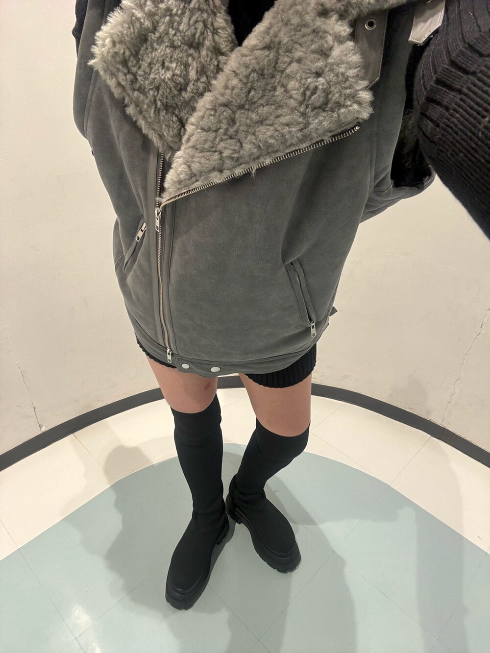 ブラック系のニット/セーター、ブラック系のその他パンツ、グレー系のムートンコートを着用したレディースの秋コーディネートの6枚目の写真