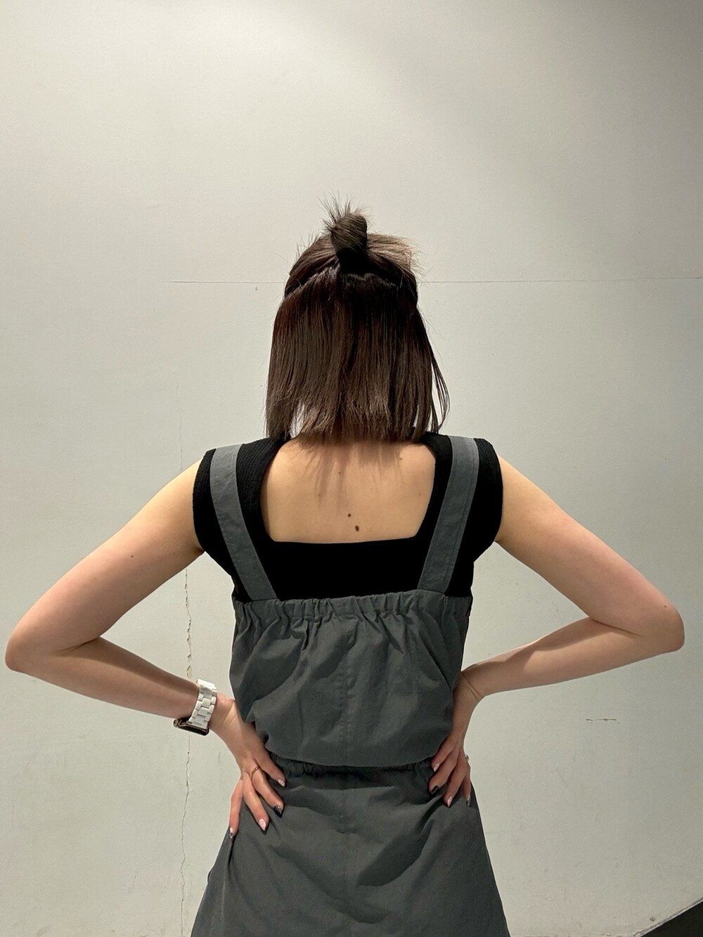 ブラック系のローファー、オレンジ系のニット/セーター、グレー系のワンピースを着用したレディースの春コーディネートの6枚目の写真