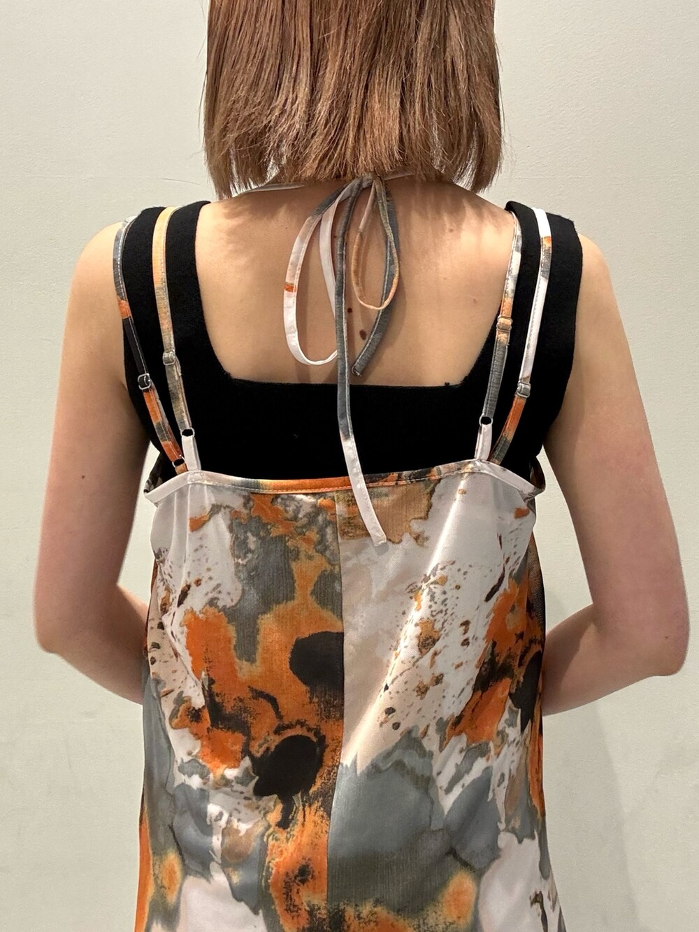 オレンジ系のショルダーバッグ、ブラック系のニット/セーター、オレンジ系のワンピースを着用したレディースの夏コーディネートの4枚目の写真