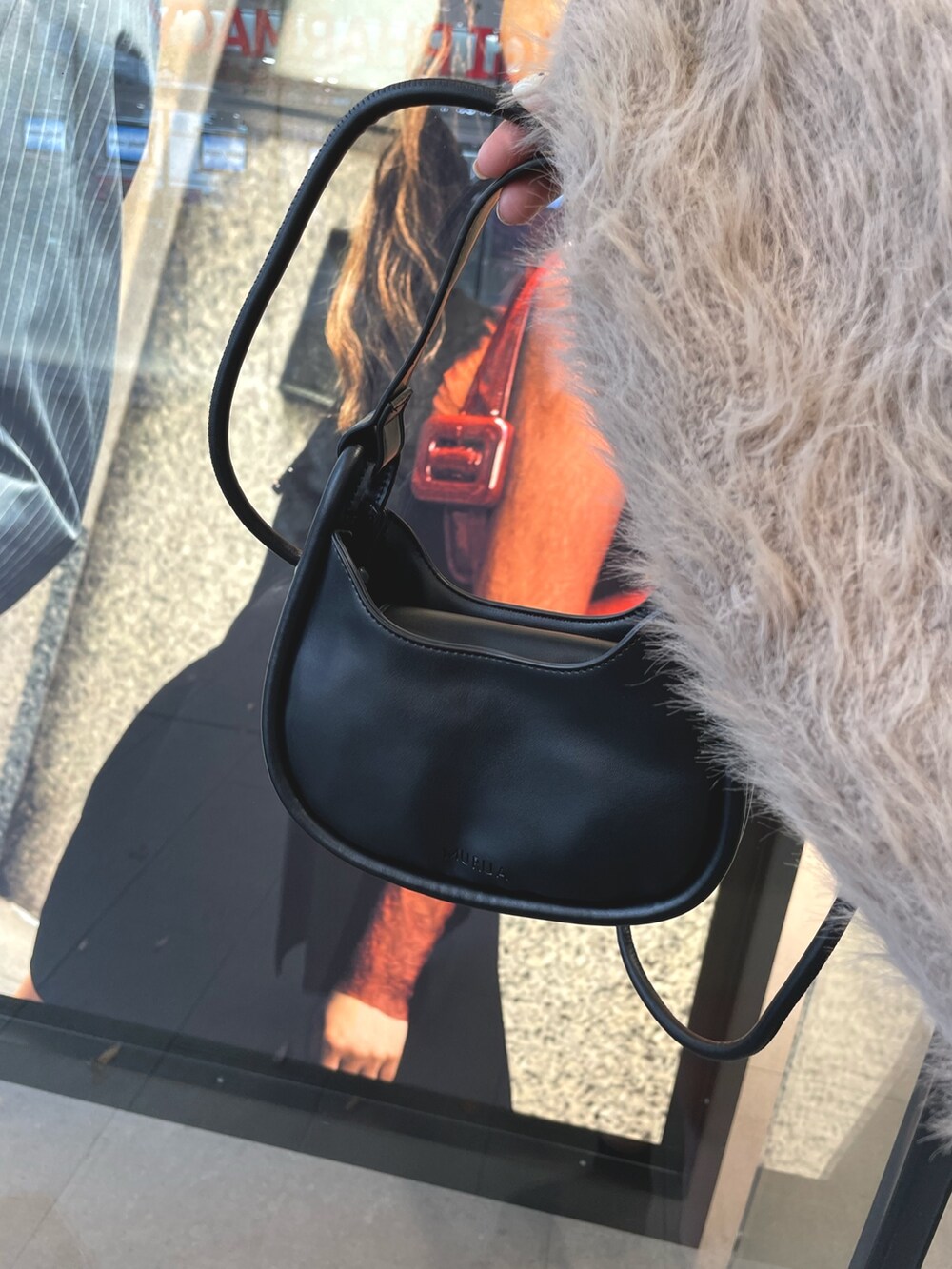 ベージュ系のカーディガン/ボレロ、ブラック系のブーツ、ブラック系のハンドバッグを着用したレディースの秋コーディネートの5枚目の写真