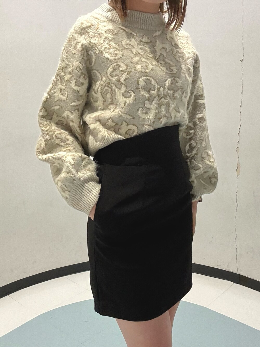 グレー系のダウンジャケット/コート、ホワイト系のニット/セーター、ブラック系のショルダーバッグを着用したレディースの秋コーディネートの5枚目の写真