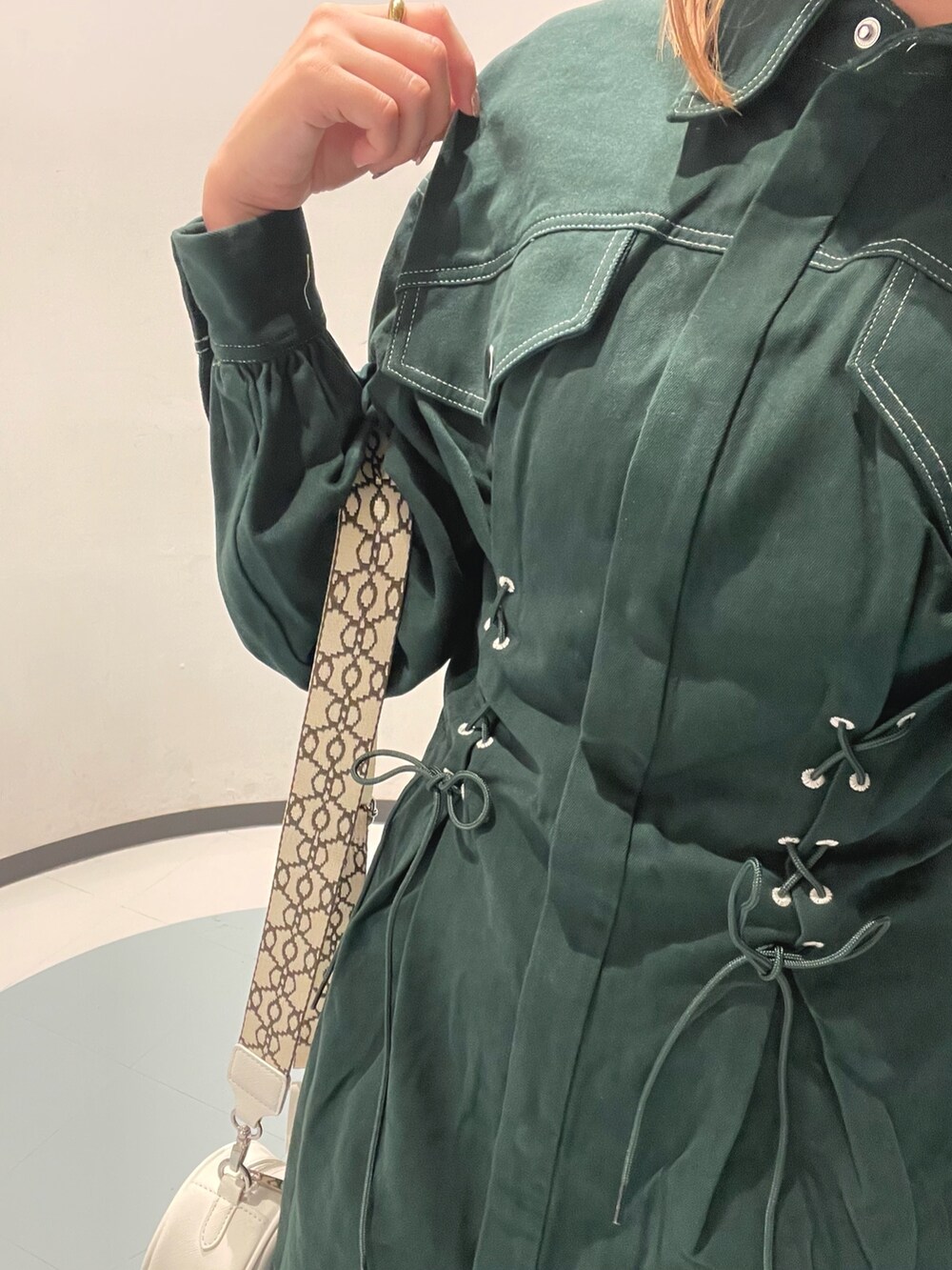 ホワイト系のショルダーバッグ、グリーン系のワンピースを着用したレディースの秋コーディネートの6枚目の写真