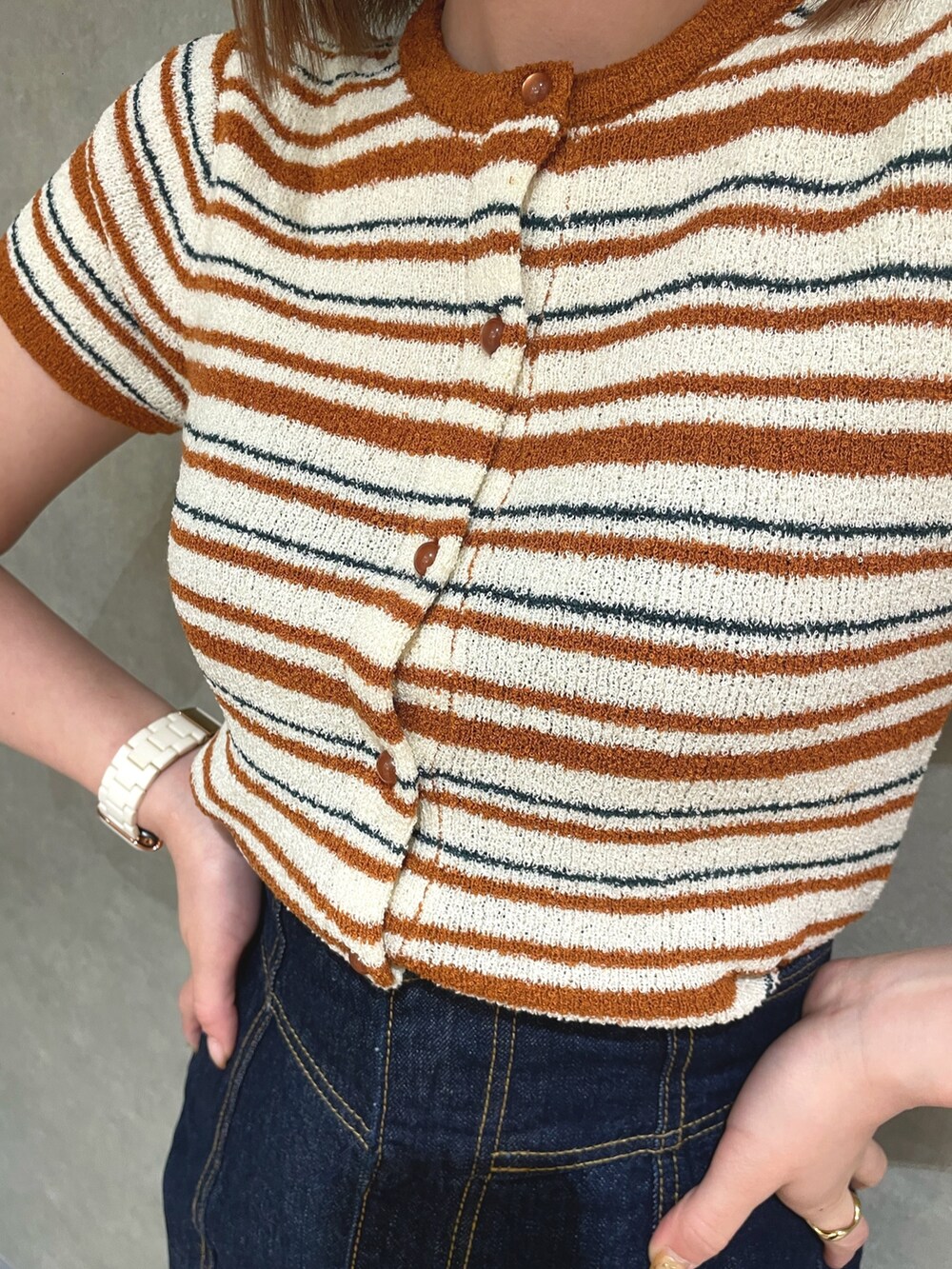 オレンジ系のカーディガン/ボレロ、ホワイト系のデニムスカート、ホワイト系のサンダルを着用したレディースの春コーディネートの5枚目の写真