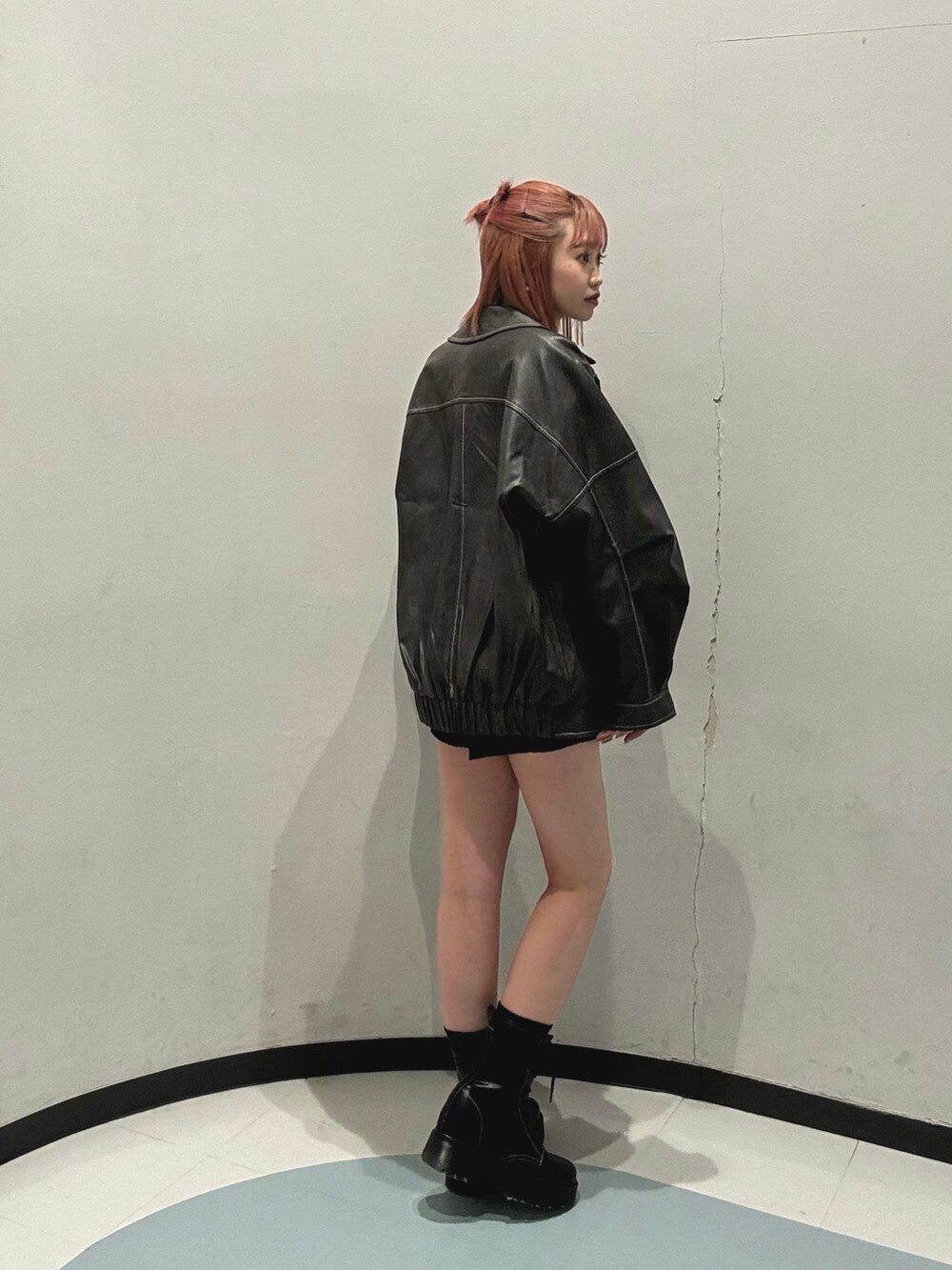 ブラック系のその他パンツ、オレンジ系のニット/セーター、グレー系のブルゾンを着用したレディースの冬コーディネートの2枚目の写真