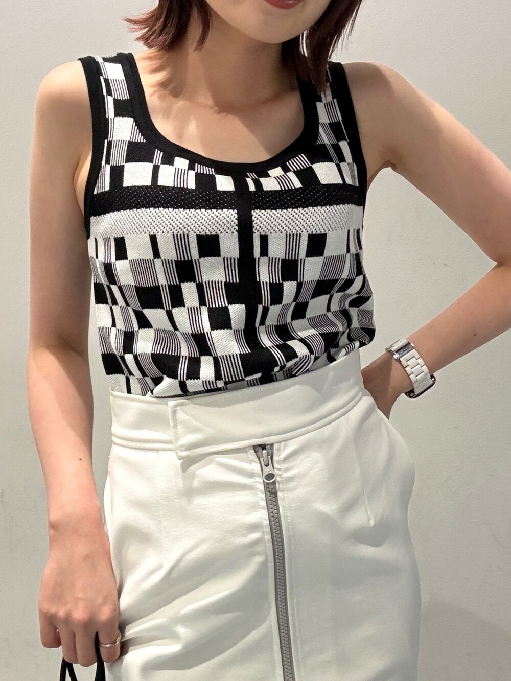 ブラック系のブーツ、ホワイト系のスカート、グリーン系のシャツ/ブラウスを着用したレディースの春コーディネートの6枚目の写真