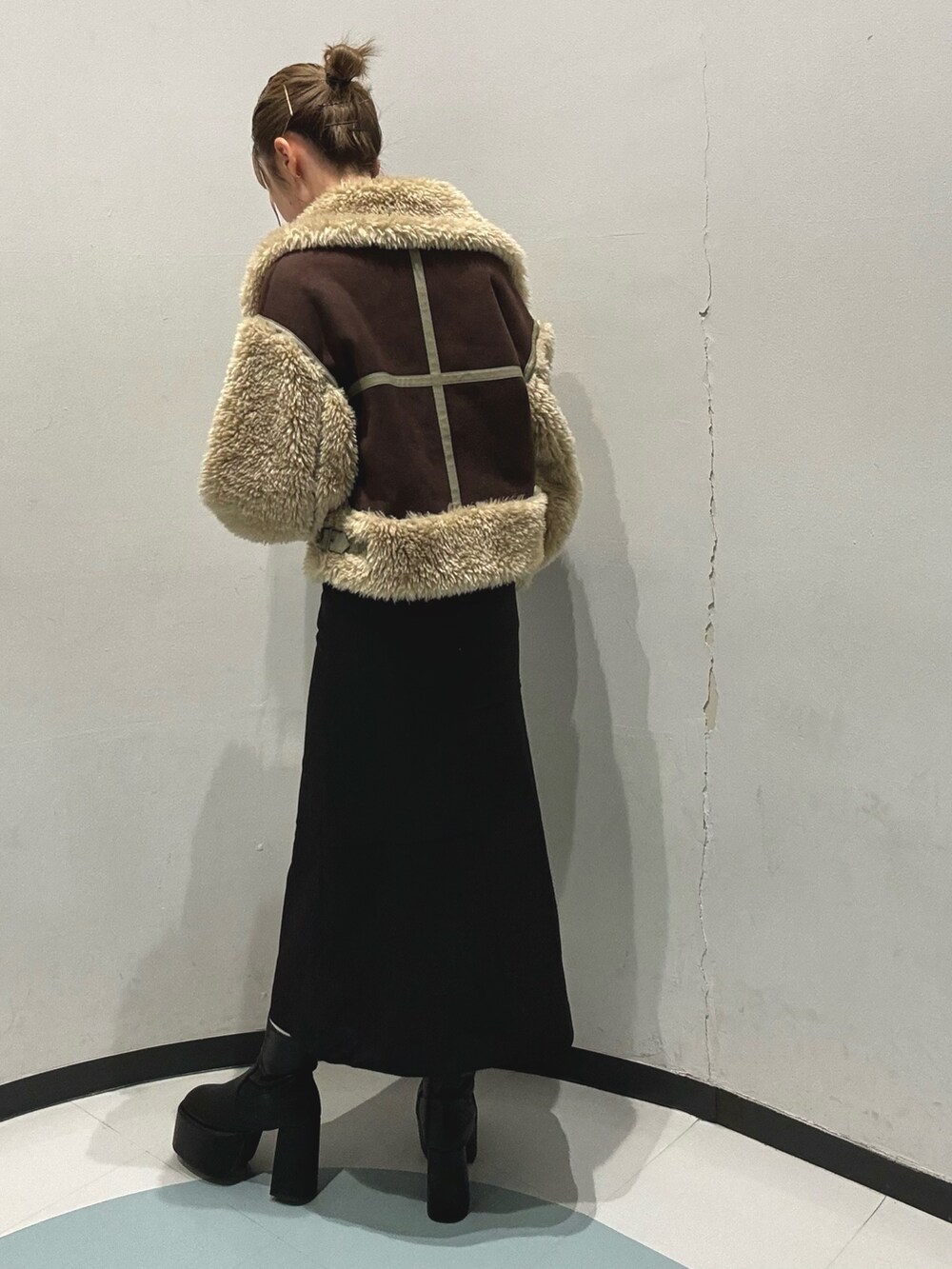 ブラック系のスカート、その他のニット/セーター、ブラウン系のムートンコートを着用したレディースの秋コーディネートの3枚目の写真