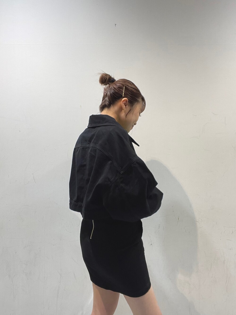 ブラック系のデニムジャケット、ホワイト系のハンドバッグ、ブラック系のサンダルを着用したレディースの夏コーディネートの3枚目の写真