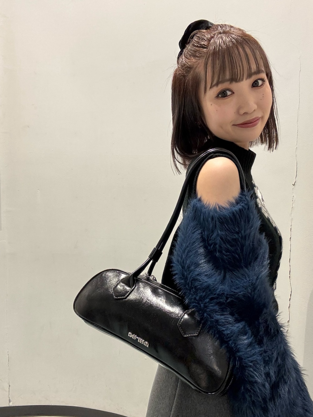 グレー系のスカート、ブラック系のブルゾン、ブラック系のニット/セーターを着用したレディースの冬コーディネートの5枚目の写真