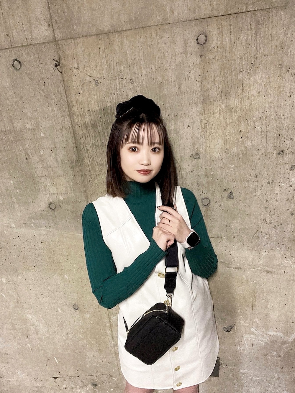 ブラック系のショルダーバッグ、グリーン系のニット/セーター、ホワイト系のワンピースを着用したレディースの冬コーディネートの2枚目の写真