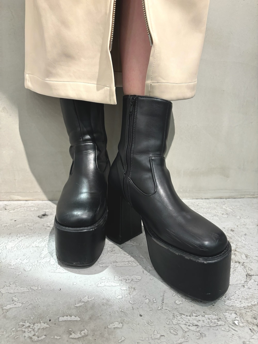 グレー系のダウンジャケット/コート、ホワイト系のニット/セーター、ブラック系のスカートを着用したレディースの秋コーディネートの7枚目の写真