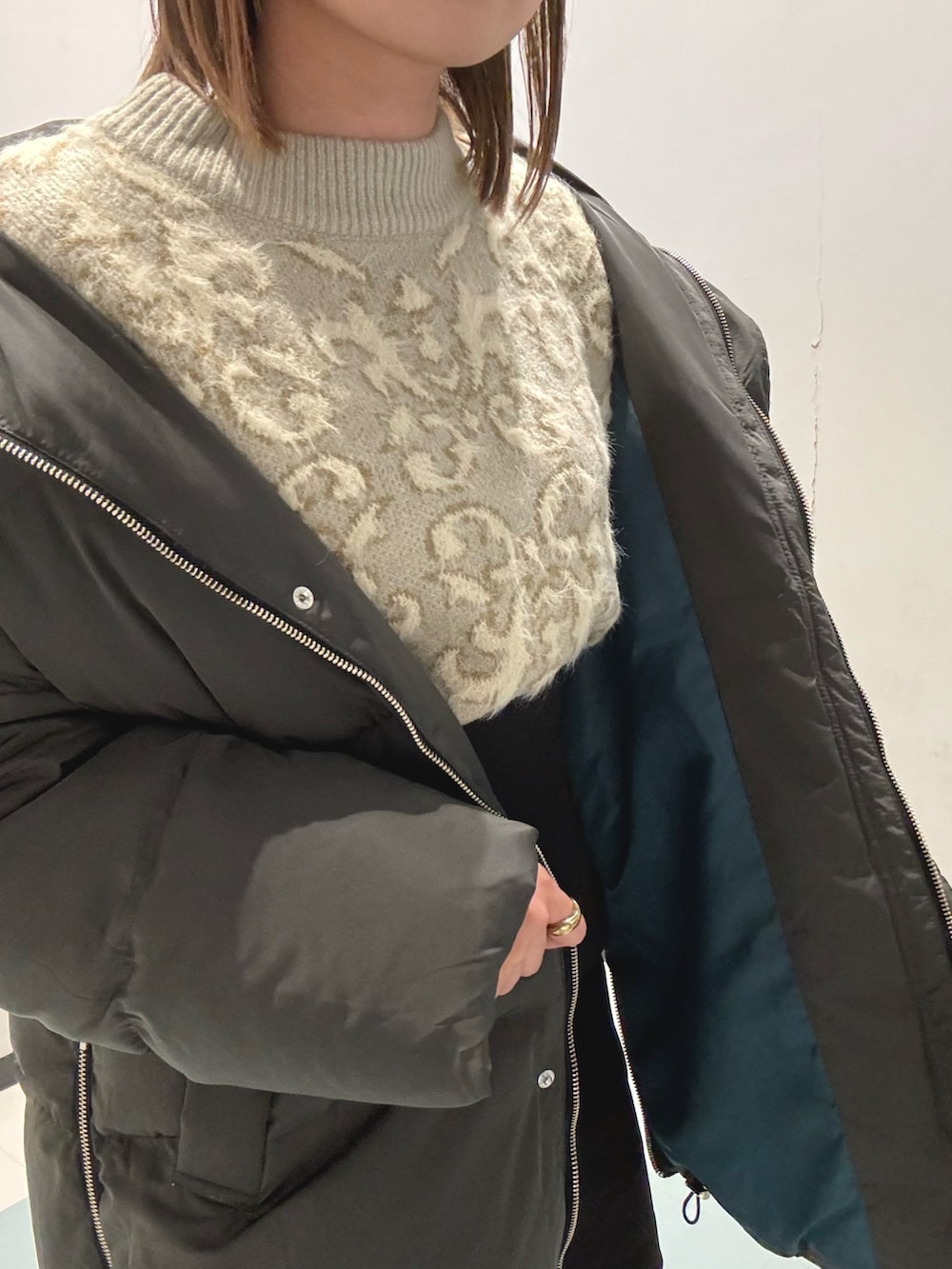 グレー系のダウンジャケット/コート、ホワイト系のニット/セーター、ブラック系のショルダーバッグを着用したレディースの秋コーディネートの7枚目の写真