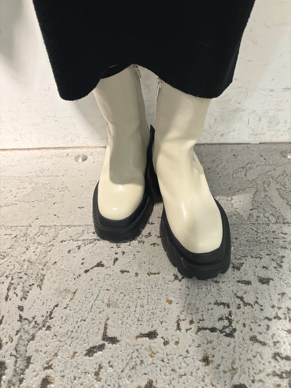 ブラック系のスカート、グリーン系のニット/セーター、ブラック系のハンドバッグを着用したレディースの冬コーディネートの7枚目の写真