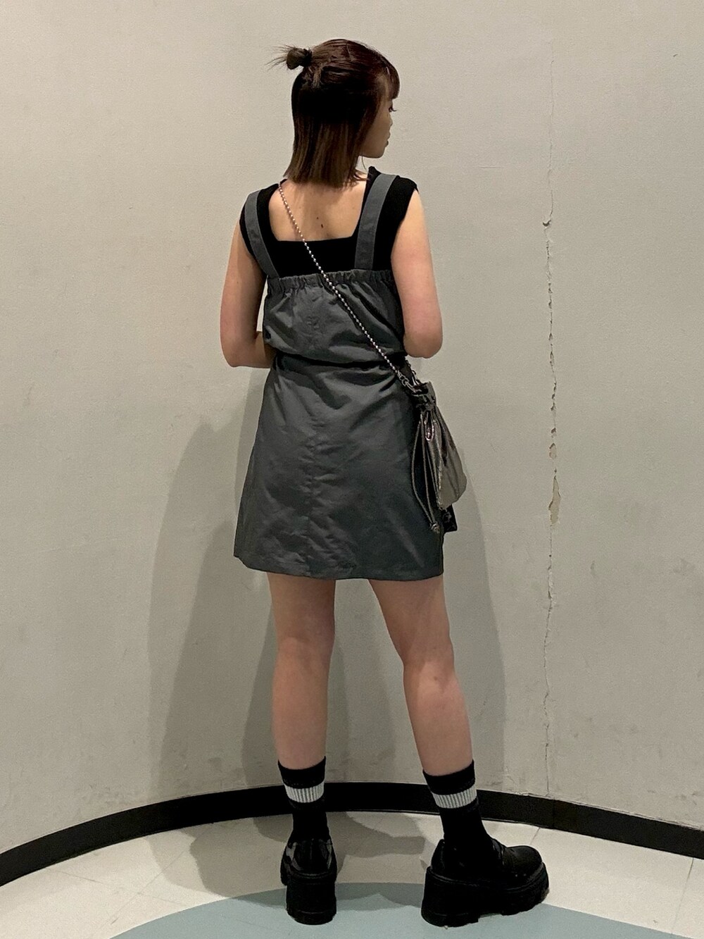 ブラック系のローファー、オレンジ系のニット/セーター、グレー系のワンピースを着用したレディースの春コーディネートの3枚目の写真