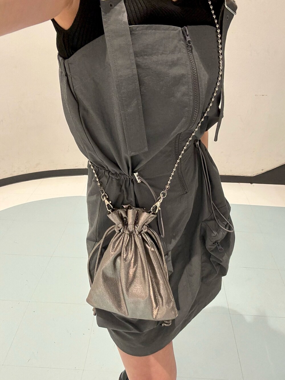 ブラック系のローファー、オレンジ系のニット/セーター、グレー系のワンピースを着用したレディースの春コーディネートの5枚目の写真