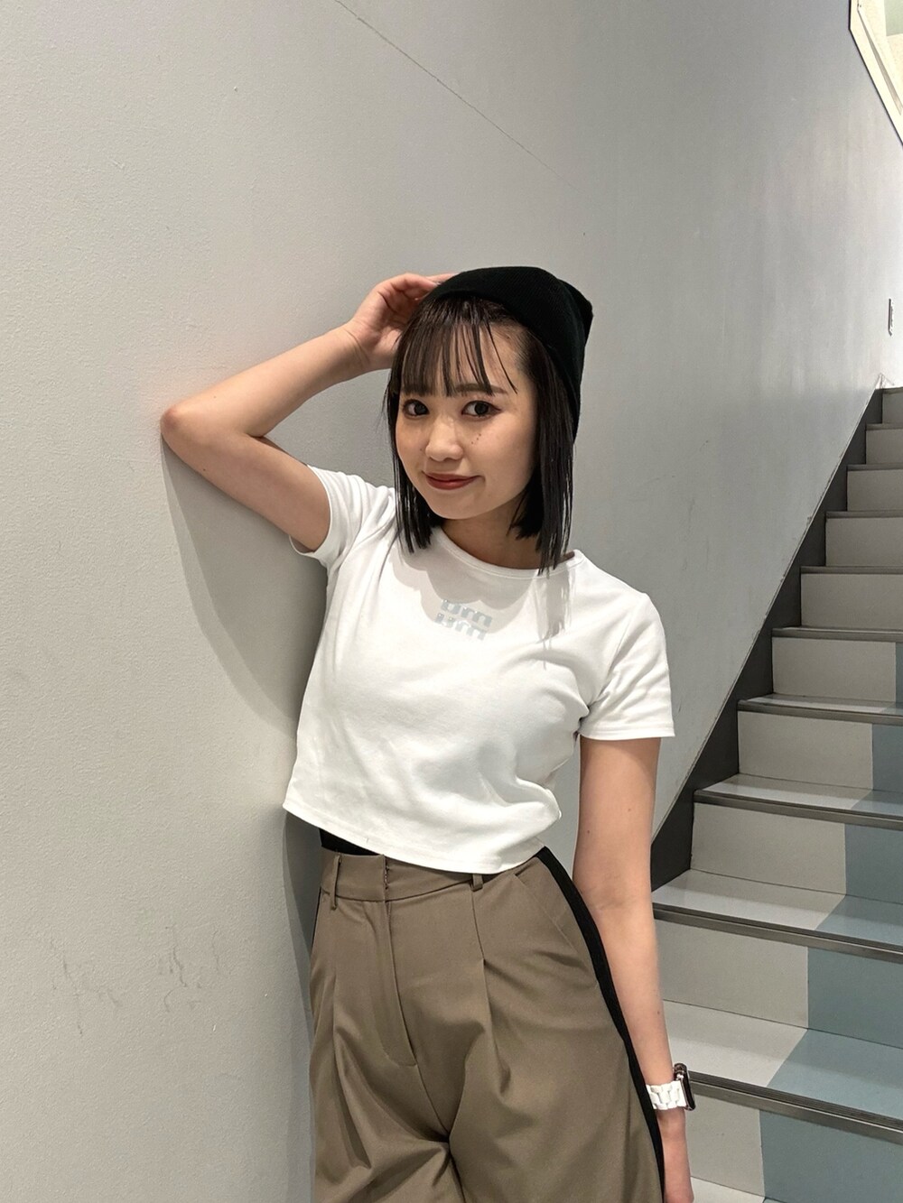 ブラック系のショルダーバッグ、ブラック系のサンダル、ホワイト系のTシャツ/カットソーを着用したレディースの春コーディネートの6枚目の写真