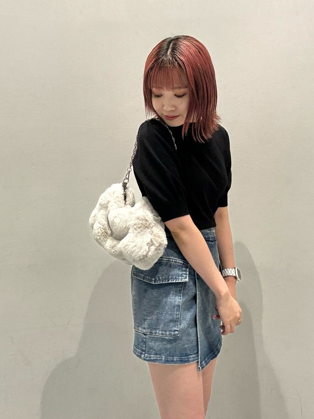 ブラック系のニット/セーター、ブルー系のスカート、ブラック系のブーツを着用したレディースの夏コーディネートの7枚目の写真