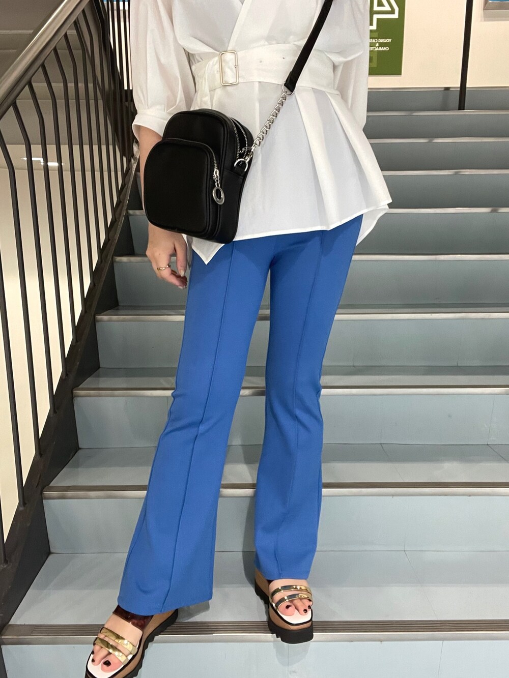 ブラック系のショルダーバッグ、ホワイト系のシャツ/ブラウス、その他のサンダルを着用したレディースの春コーディネートの6枚目の写真