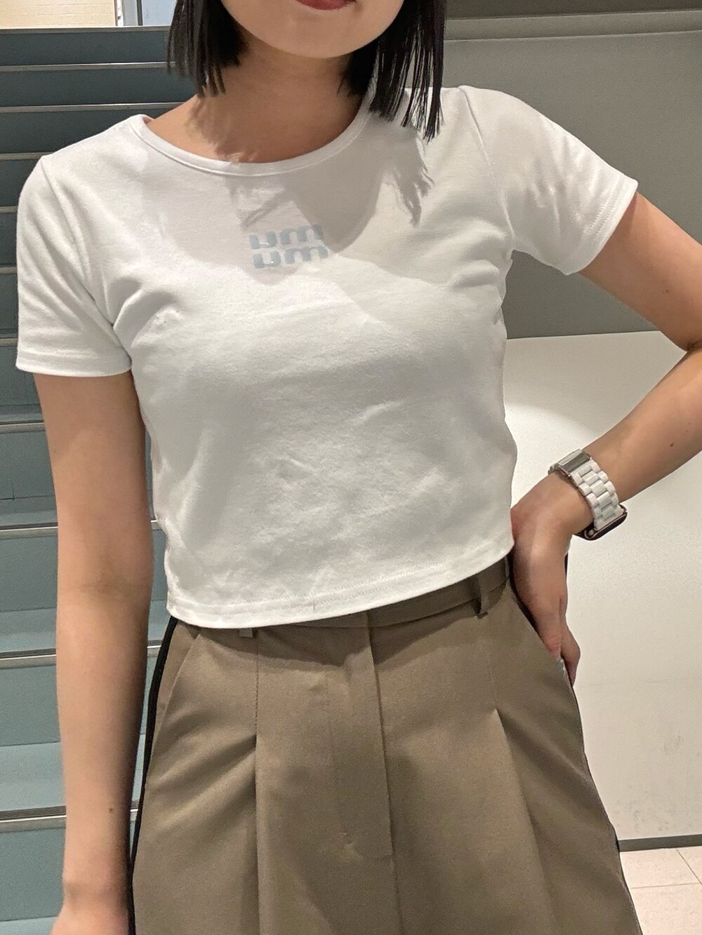 ブラック系のショルダーバッグ、ブラック系のサンダル、ホワイト系のTシャツ/カットソーを着用したレディースの春コーディネートの4枚目の写真