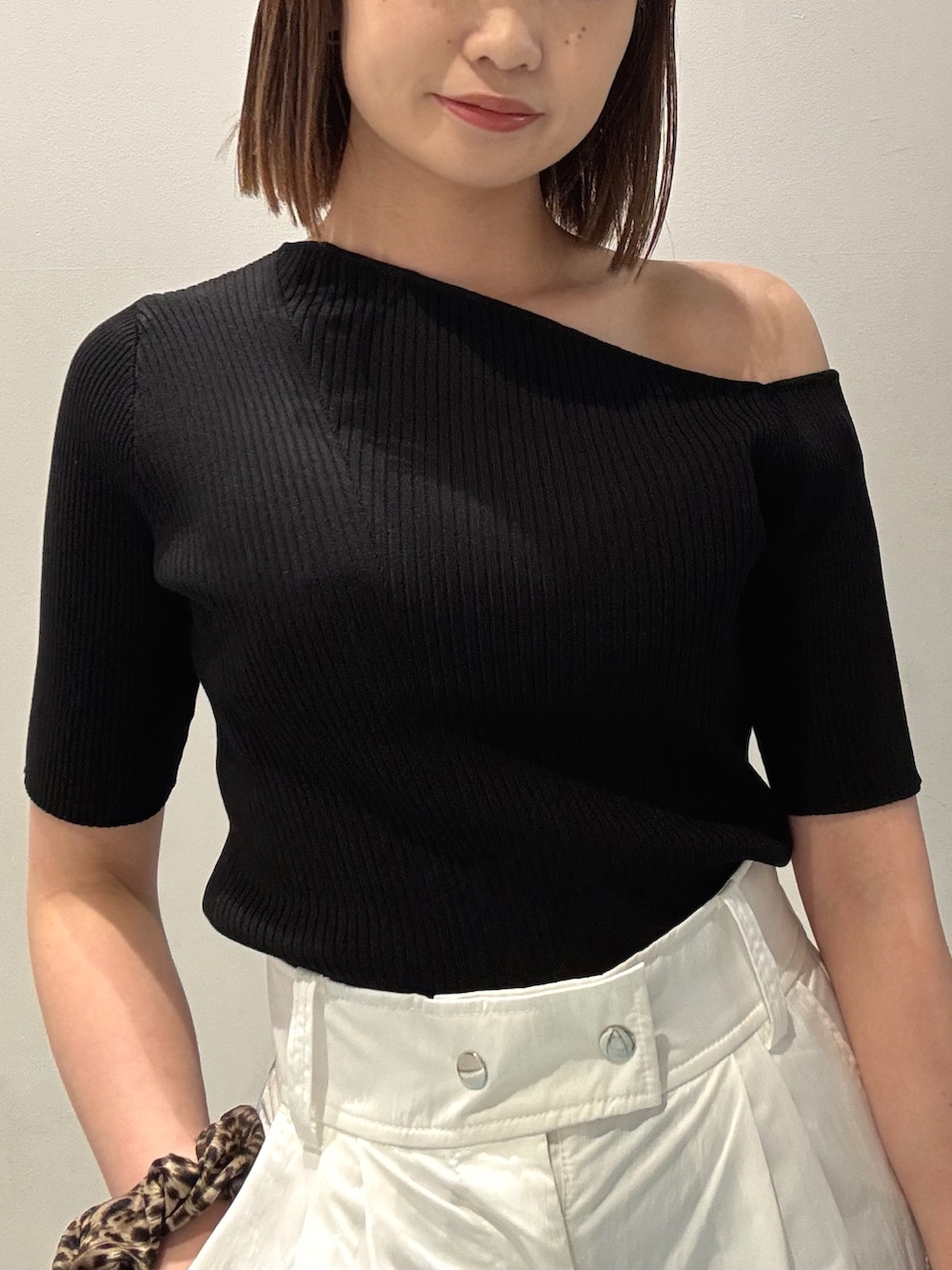 ブラック系のニット/セーター、ホワイト系のカーゴパンツ、ブラック系のサンダルを着用したレディースの春コーディネートの4枚目の写真